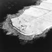 Oblique aerial view of Orkney, Car Ness, Car Ness and Wellington Batteries, taken from the NW.  Visible are the gun-emplacements, battery observation towers, searchlight platforms and Nissen huts for both batteries. The site of a heavy anti-aircraft battery is just discernable to the S.