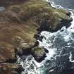 Oblique aerial view centred on the remains of the settlement and lazy beds with the lighthouse adjacent, taken from the NE.