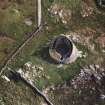 Oblique aerial view centred on the remains of the broch, taken from the WNW.