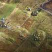 Oblique aerial view centred on the remains of the stone circle, chambered cairn and stone alignments with the township and lazy beds adjacent, taken from the WSW.