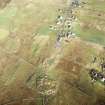 Oblique aerial view centred on the remains of the stone circle, chambered cairn and stone alignments with the township and lazy beds adjacent, taken from the S.