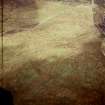 Oblique aerial view centred on the remains of the cairn, enclosure and settlement, taken from the WSW.