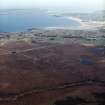 General oblique aerial view looking across the peat cutting and the remains of the chambered cairn towards the modern crofting township of Aird Thunga, taken from the NW.