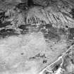 Achnahuie, oblique aerial view, taken from the SW, showing an area with a hut-circle, small cairns, lynchets and a possible hut in the centre of the photograph.