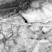 Oblique aerial view of the remains of the hut-circles, enclosures and small cairns, taken from the SE.