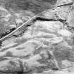 Oblique aerial view of the remains of the hut-circles, enclosures, small cairns and field system, taken from the NW.