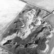 Oblique aerial view centred on the remains of the quarry and windmill, taken from the SW.