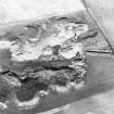 Oblique aerial view centred on the remains of the quarry and windmill, taken from the S.