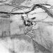 Oblique aerial view centred on the farmstead and the remains of the building, taken from the NW