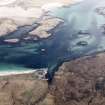 Oblique aerial view centred on the remains of the dun with the remains of the fish trap adjacent, taken from the WSW.