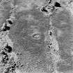 Oblique aerial view of Garbeg centred on the remains of a hut-circle in an area of hut-circles, small cairns, a field-system and rig, taken from the NE.