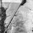 Oblique aerial view centred on the cropmarks of the enclosure, pit-alignment, linear cropmarks, pits and rig with standing stone adjacent, taken from the SE.