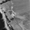 Coulmore, oblique aerial view, taken from the SE, centred on the remains of a possible castle and the cropmarks of an enclosure and rig.