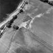 Coulmore, oblique aerial view, taken from the ESE, centred on the remains of a possible castle and the cropmarks of an enclosure and rig.