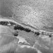 Coulmore, oblique aerial view, taken from the NE, centred on the remains of a possible castle and the cropmarks of an enclosure and rig.