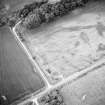 Oblique aerial view centred on the cropmarks of the pits and cropmarks, taken from the S.