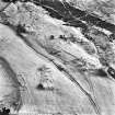 Ballourie, oblique aerial view, taken from the E, showing the remains of a township across the photograph, and rig in the foreground.