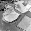 Raebreck, oblique aerial view, taken from the NE, centred on the cropmarks of a palisaded enclosure and two possible souterrains. The remains of a township are visible in the top left-hand corner of the photograph.