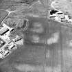 Mains of Gartan, oblique aerial view taken from the SE, centred on the remains of a motte and the cropmark of a possible enclosure.  The Mains of Garten is visible in the left centre of the photograph.  A possible township is visible in the right hand corner of the photo.