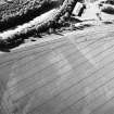 Pilmuir, oblique aerial view, taken from the SSE, centred on the cropmarks of a barrow cemetery.