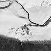 Oblique aerial view of Belnabodach centred on the remains of a house, farmhouse, farmstead and rig, taken from the SW.