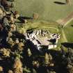 Oblique aerial view of Kildrummy castle centred on the remains of the castle, taken from the W.