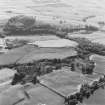 Oblique aerial view of Wardhouse Home Farm, centred on the remains of rig, small cairns and farmstead with hut-circles, small cairns, rig, cottages and quarry adjacent, taken from the NE.