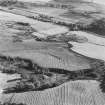 Oblique aerial view of Wardhouse Home farm centred on the remains of rig and small cairns with cairns, field-system, quarry and cottage adjecent, taken from the NW.