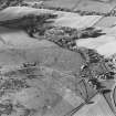 Oblique aerial view of Wardhouse Home Farm centred on the remains of hut-circles, small cairns and rig with cairns, field system, rig, quarry and cottage adjacent, taken from the E.