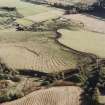 Oblique aerial view of Wardhouse Home Farm centred on the remains of rig, small cairns and farmstead with hut-circles, cairns and cottage adjacent, taken from the NW.