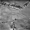 Tillyorn, oblique aerial view, taken from the WSW, showing the cropmark of a settlement enclosure in the centre of the photograph.