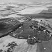 Oblique aerial view centred on the remains of quarries taken from the SE.