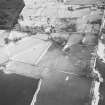 Oblique aerial view of the remains of rig, hut-circle, small cairns and quarries taken from the NNE.