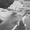 Oblique aerial view of the remains of rig, hut-circle, small cairns and quarries taken from the NW.