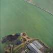 Oblique aerial view centred on the remains of the recumbent stone circle with the farmsteading adjacent, taken from the WNW.