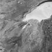 Oblique aerial view of Gortan centred on the remains of a possible bank, with a farmsteading and the remains of a building adjacent, taken from the NW.