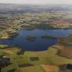 General oblique aerial view of the Lake of Menteith centred on the priory and crannog, taken from the WSW.