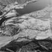 Oblique aerial view of Anie centred on a farmstead, the remains of a field-system, rig, military road and limekiln, taken from the SE.