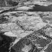 Oblique aerial view of Anie centred on a farmstead, the remains of a field-system, rig and a military road, taken from the E.