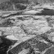 Oblique aerial view of Anie centred on a farmstead, the remains of a field-system, rig and a military road, taken from the ESE.