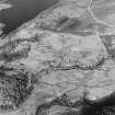 Oblique aerial view of Anie centred on a farmstead, the remains of a field-system, rig, military road and limekiln, taken from the SE.