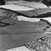 Dalginross, oblique aerial view, taken from the E, centred on the cropmarks of the Roman Temporary Camp. The Roman Fort is visible in the centre right of the photograph.