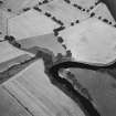 Oblique aerial view from SE showing site of Roman Fort and possible barrow in field to S of River Tay.