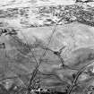 Corrymuckloch, oblique aerial view, taken from the S, showing the Crieff to Dalnacardoch military road running across the centre of the photograph. An area of hut-circles, clearance cairns and field banks is visible in the centre. A hoard find spot, in peat cuttings, is visible as a dark patch in the centre of the photograph.