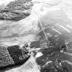 Oblique aerial view centred on the remains of trackways, field banks and sheepfold with standing stones adjacent, taken from the ENE.