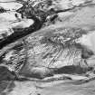 Oblique aerial view centred on the remains of the farmstead, head-dyke, field banks and rig, taken from the SE.