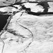 Oblique aerial view centred on the remains of the field system with farmstead and enclosure adjacent, taken from the WNW.