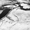 Oblique aerial view centred on the remains of the field system with farmstead and enclosure adjacent, taken from the WNW.