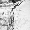 Oblique aerial view centred on the remains of buildings, enclosure, hut and lazy-beds with huts, enclosures, field-system, plantation bank, sheepfold, quarry, trackways, farmstead and field banks adjacent, taken from the SW.