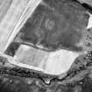 Oblique aerial view centred on the site of the enclosed cremation cemetery with the cropmarks of the enclosure adjacent, taken from the SE.